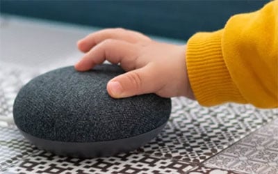 small child touching a smart speaker